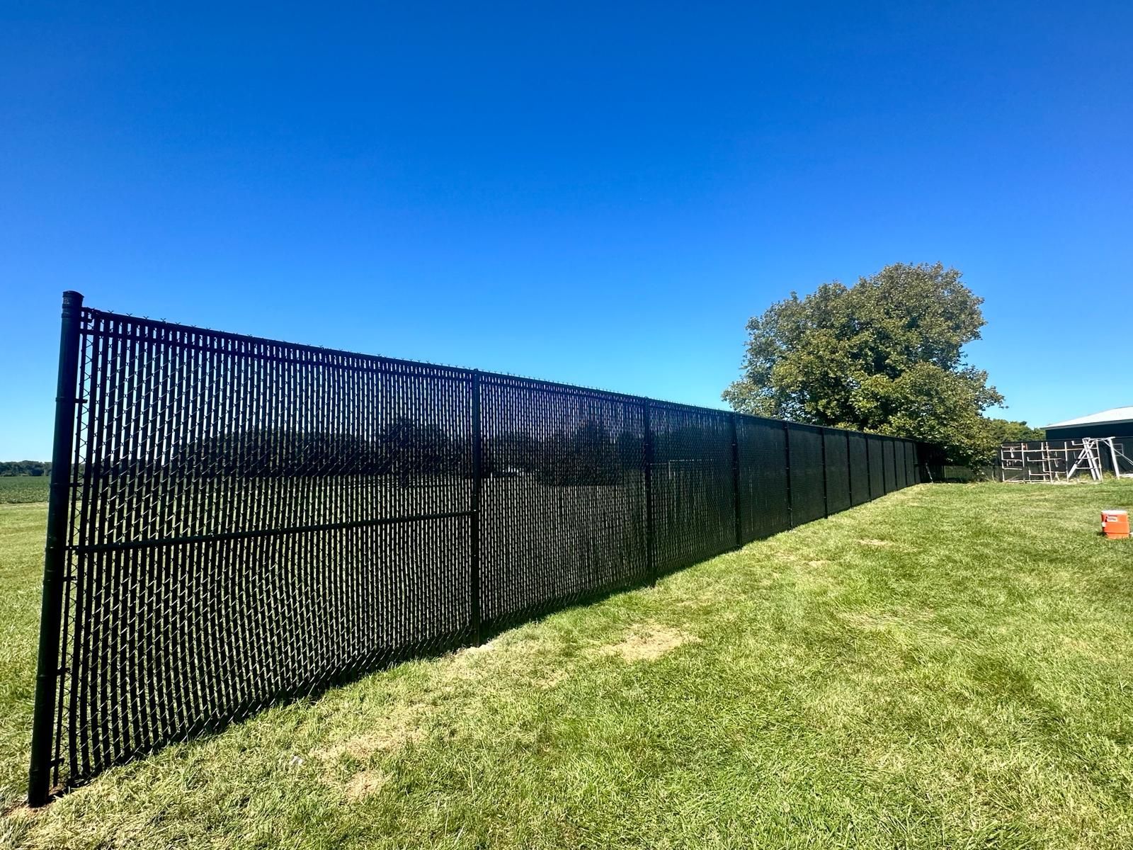 A black metal fence is sitting in the middle of a grassy field.