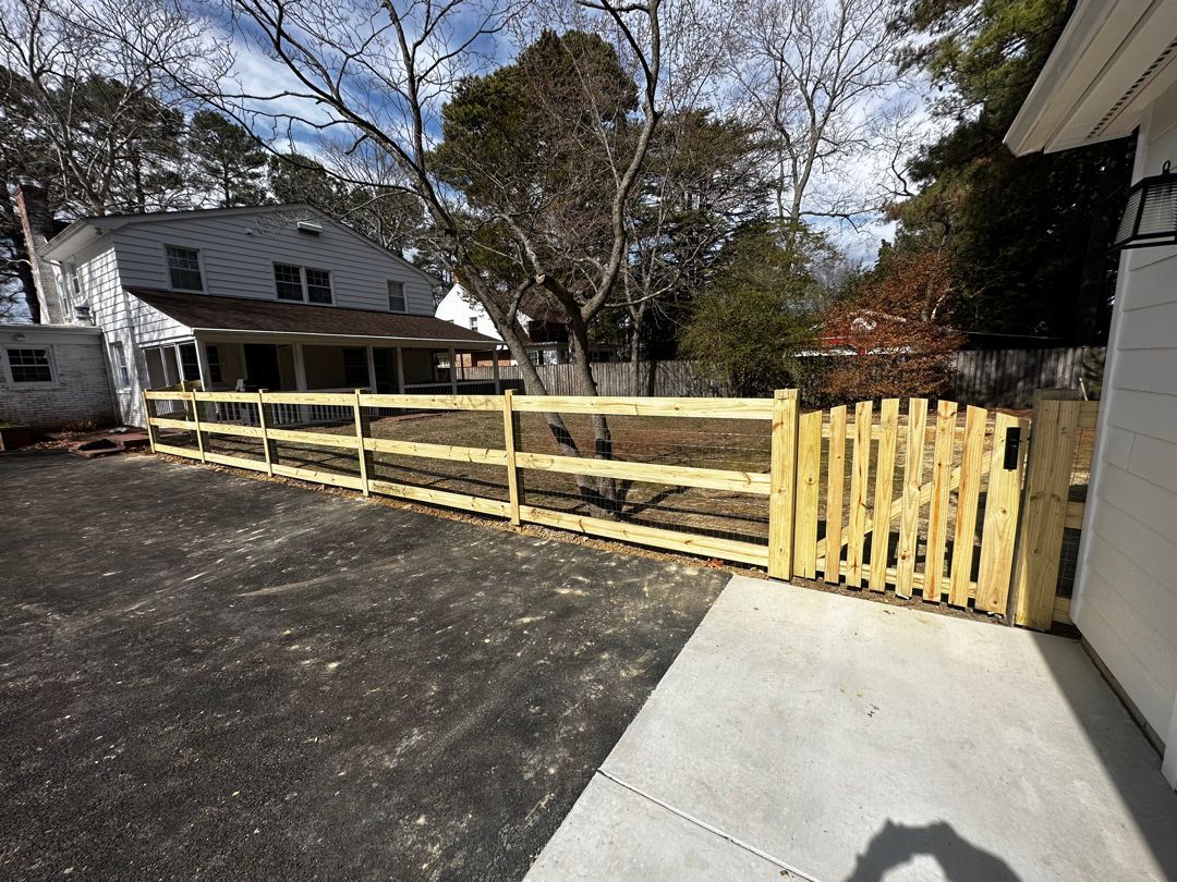3 rail wood paddock with black wire and single gate.