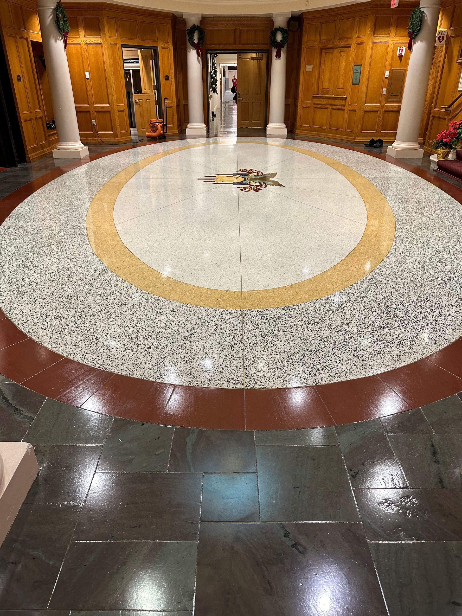 Round, patterned entryway, featuring a central design surrounded by concentric circles, and columns.