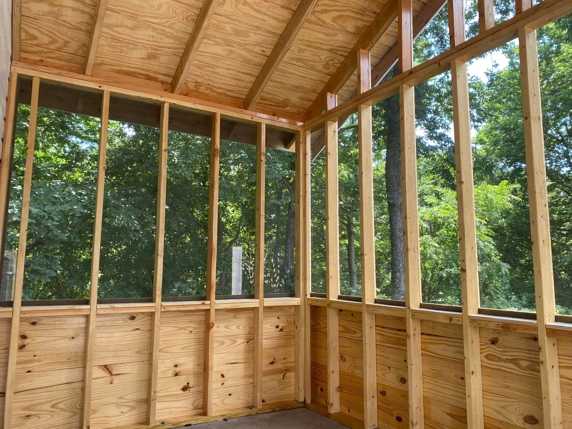 A screened in porch under construction with trees