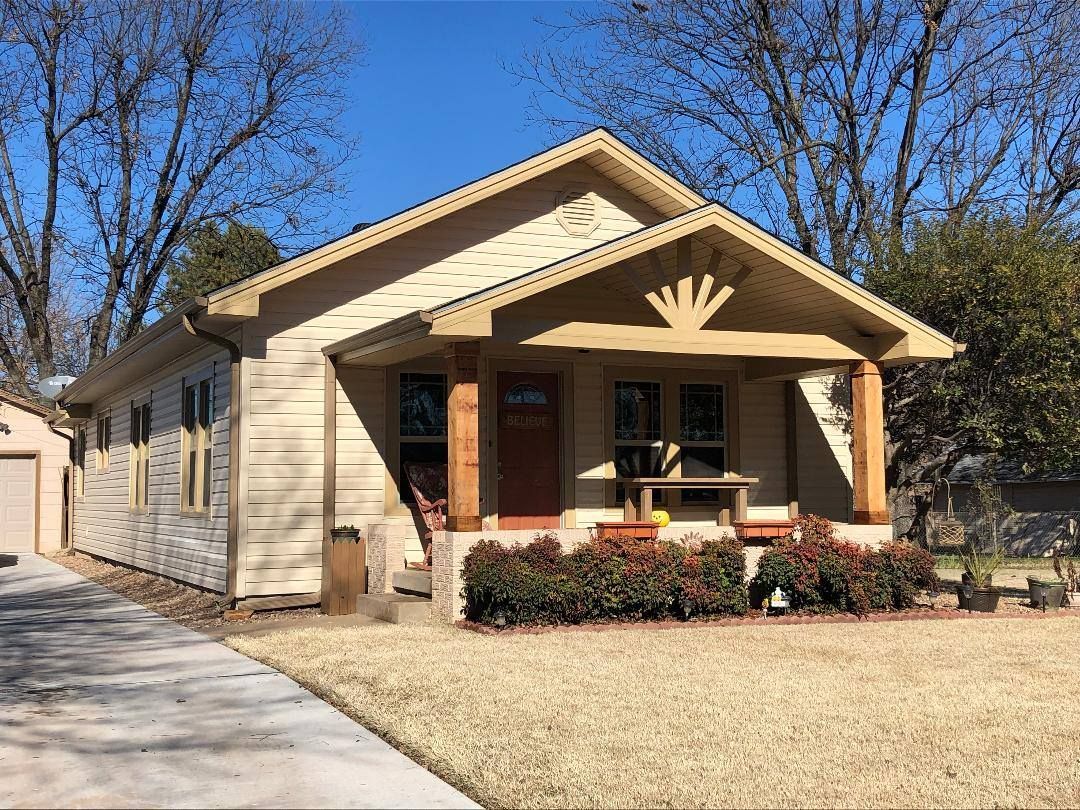 A small house with a porch and a driveway