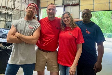 A group of people are posing for a picture in a garage