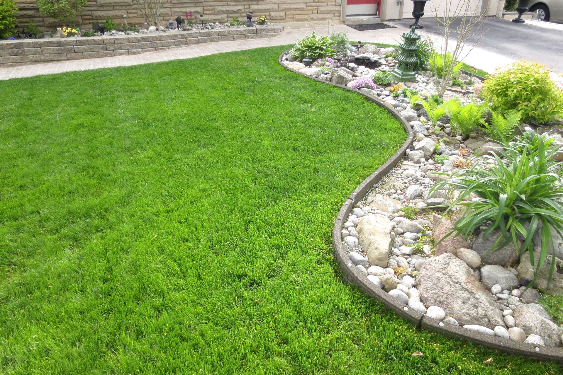 A lush green lawn bordered by a curved landscaping bed 