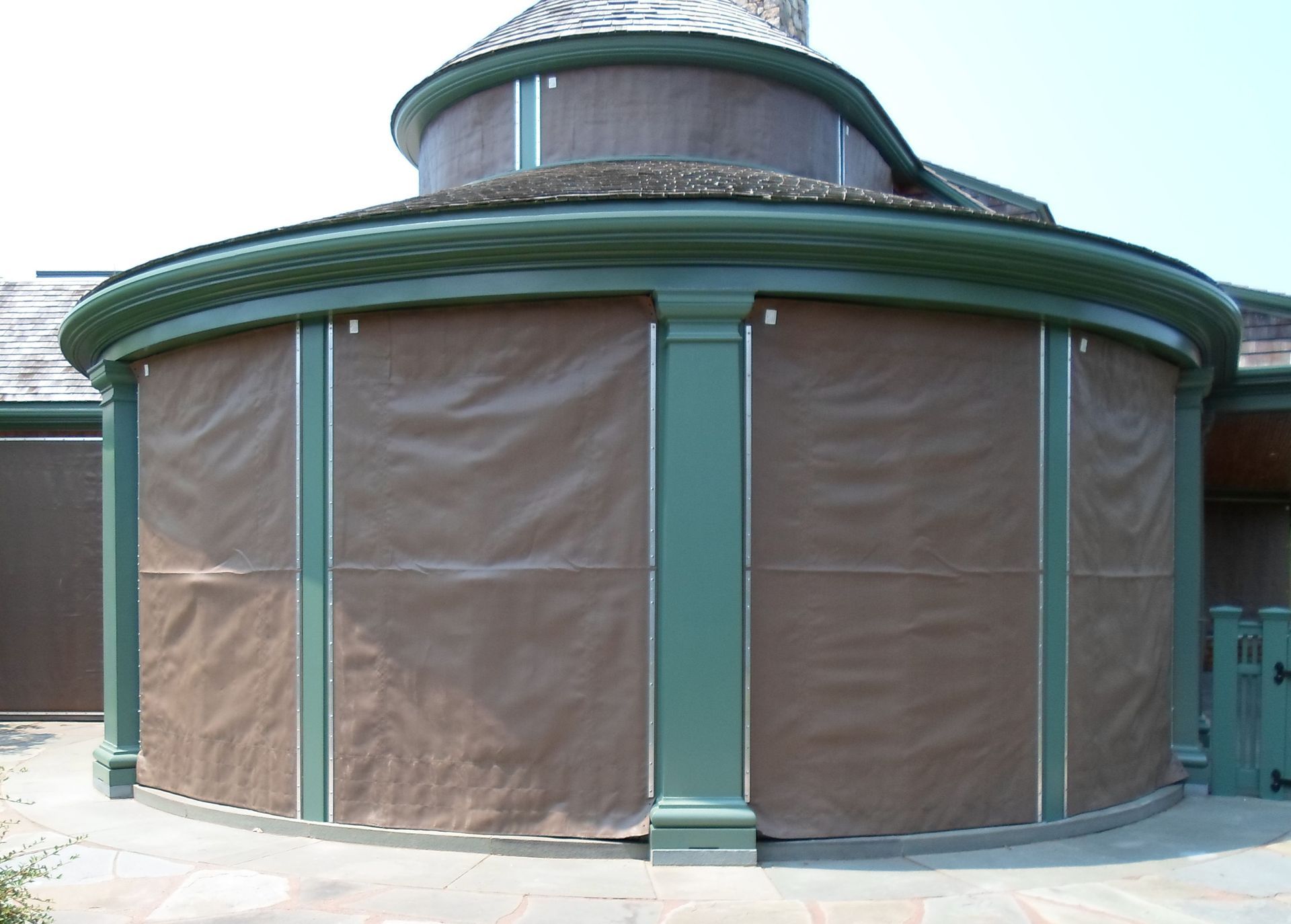 Round green pavilion with tan covered windows and a domed roof