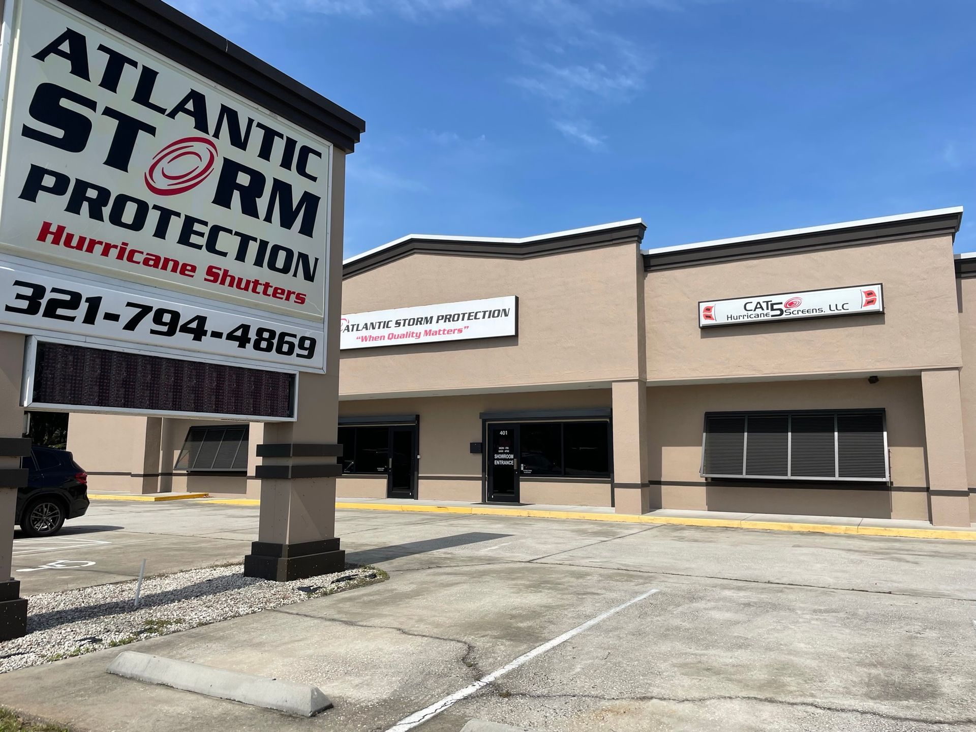 Atlantic Storm Protection storefront with sign and empty parking lot under a blue sky