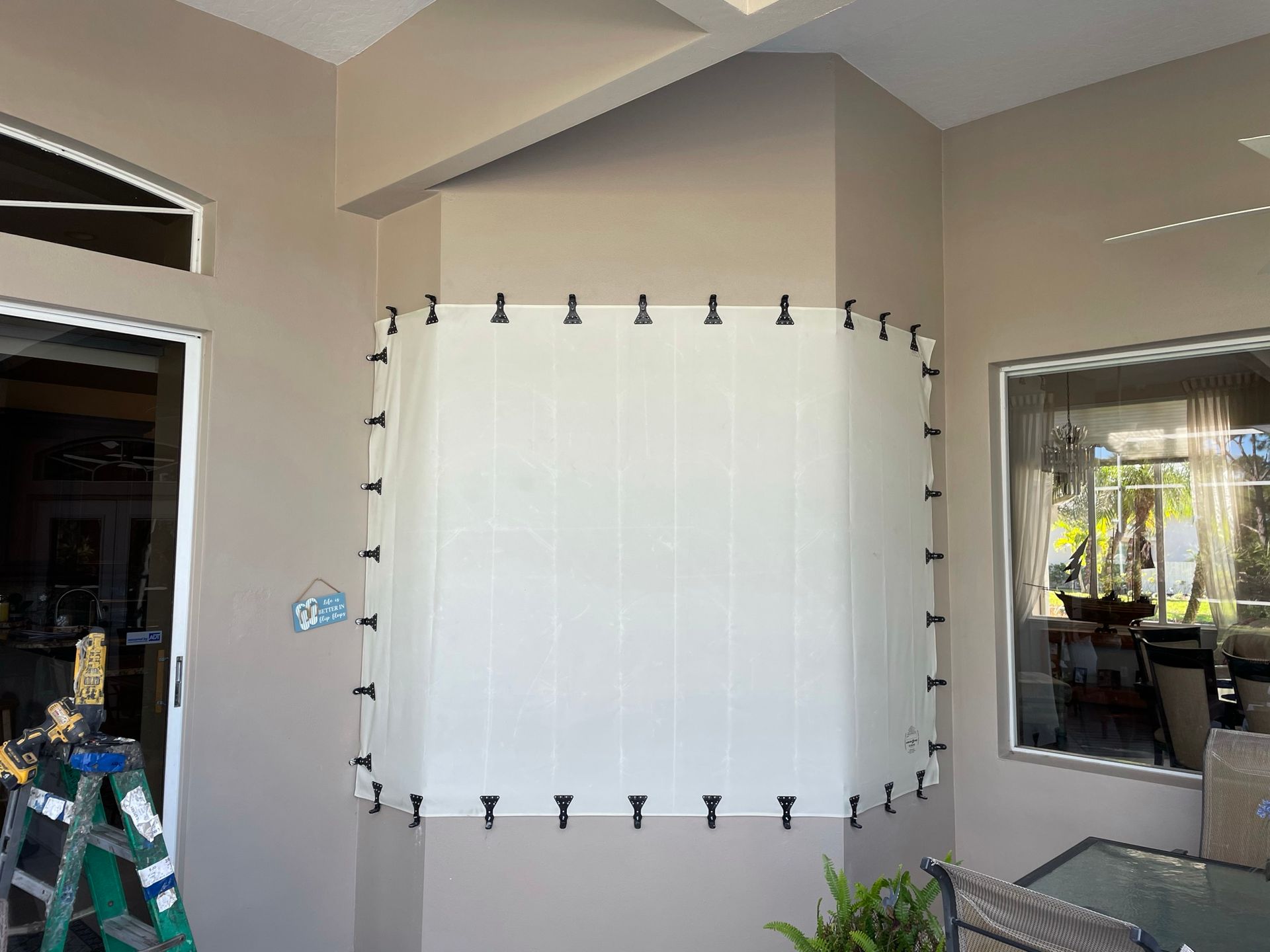 White fabric panel installed on an indoor wall in a room with beige walls and windows