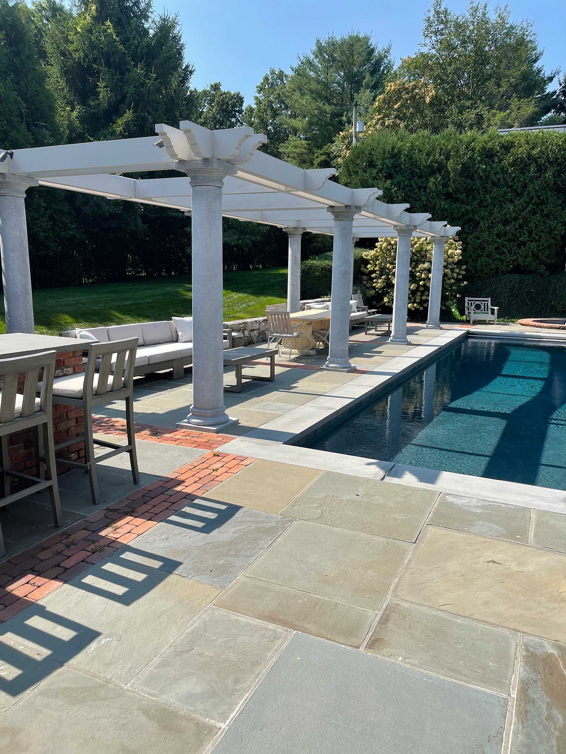a large swimming pool with a pergola over it