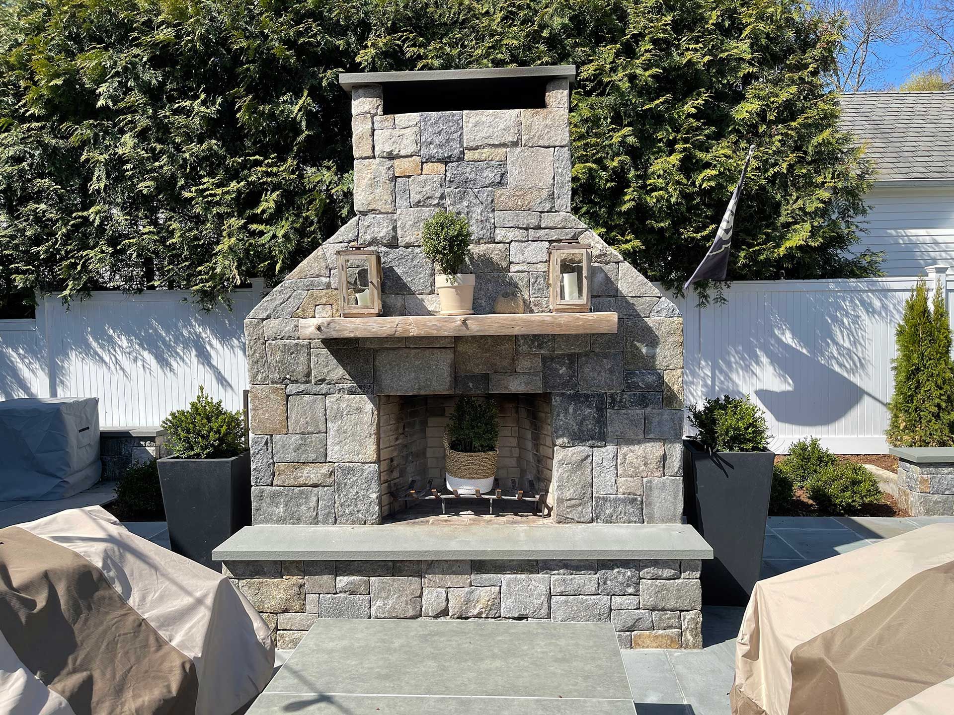 a stone fireplace is sitting on a patio