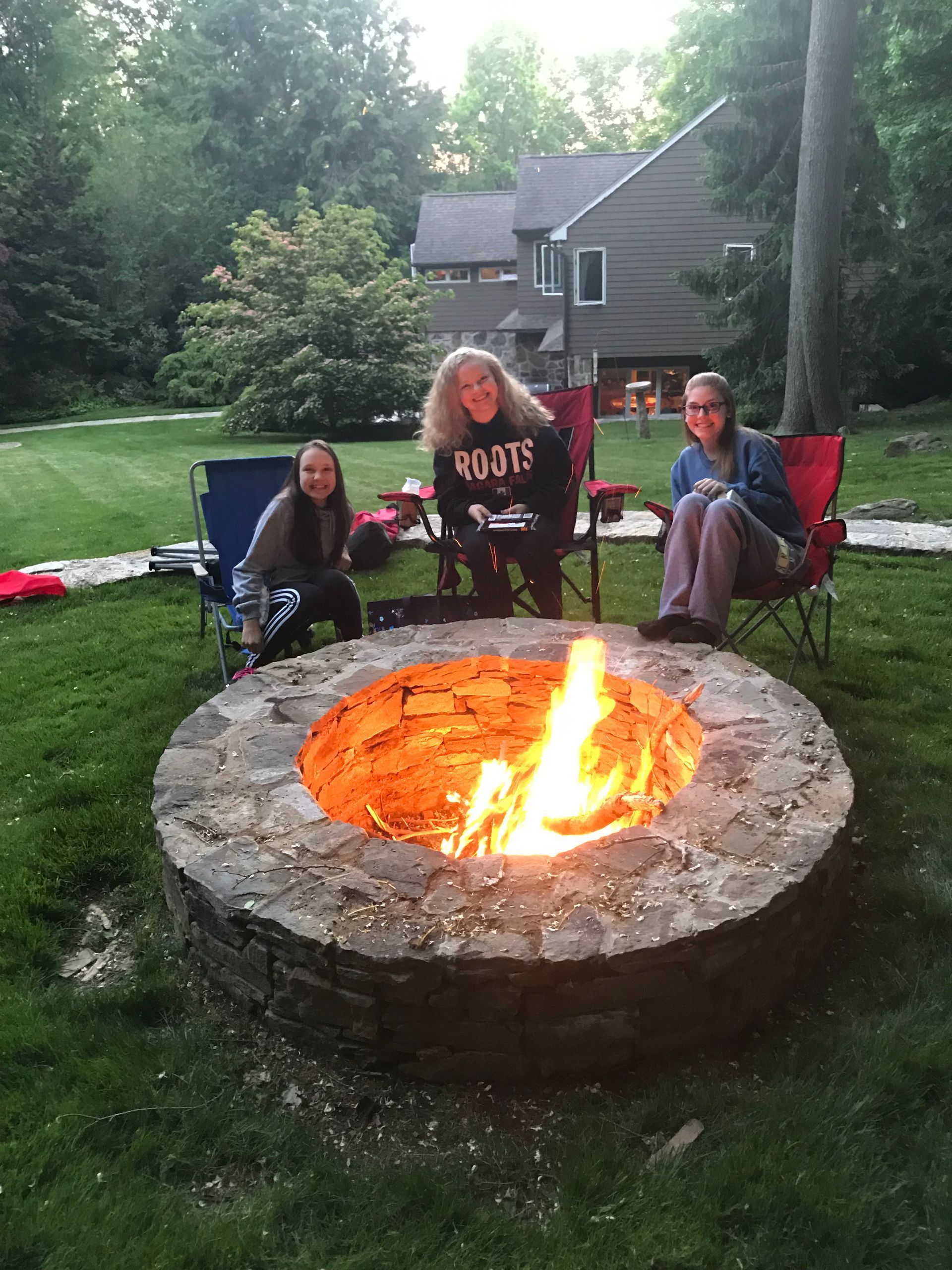 a group of people are sitting around a firepit