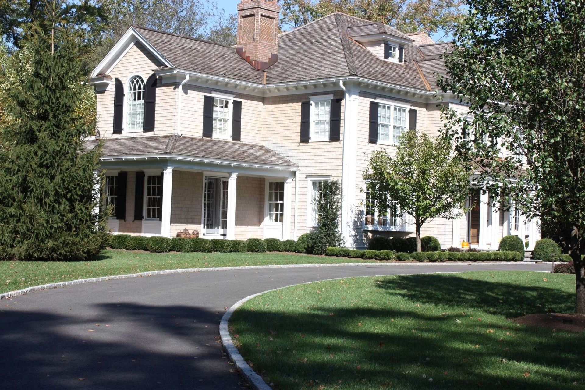 A large house with a curved driveway leading to it