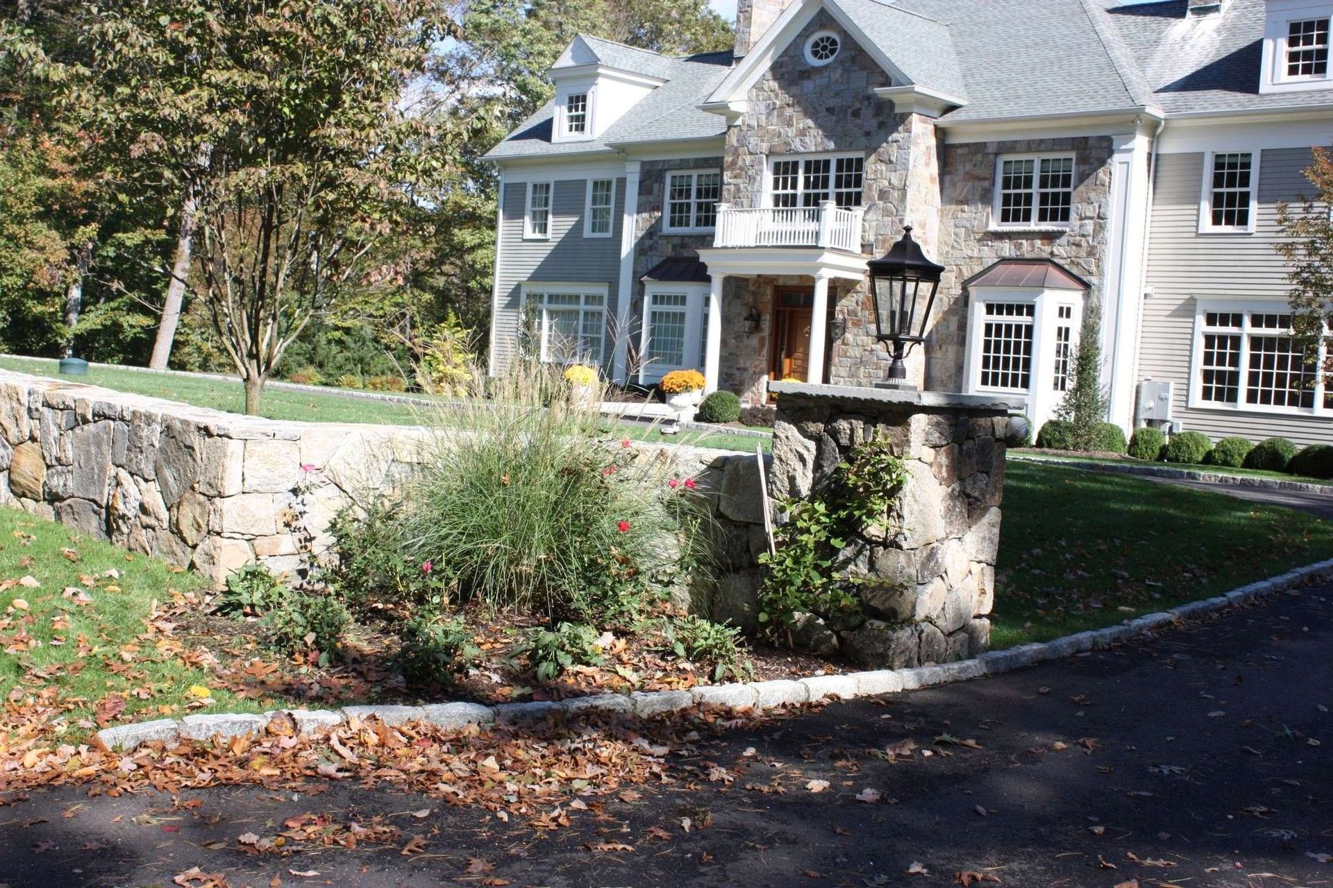 A large house with a stone wall in front of it