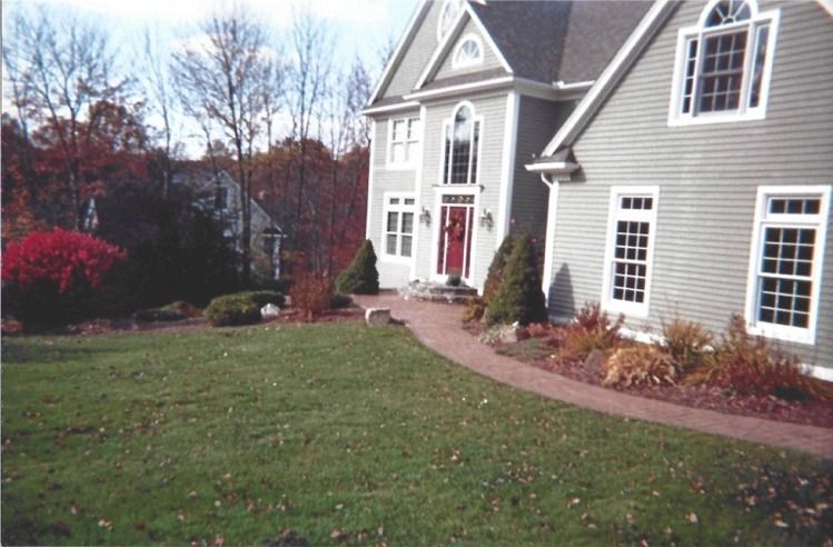 A large house with a red door and a walkway leading to it