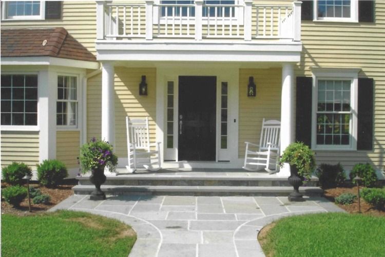 A house with a porch and rocking chairs on it