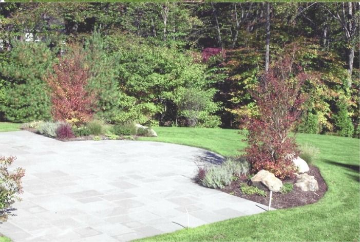 A lawn with trees and rocks in the middle of it