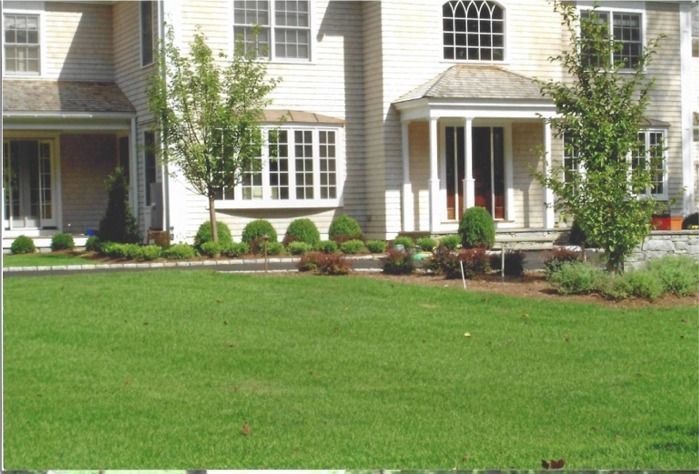 A large house with a lush green lawn in front of it