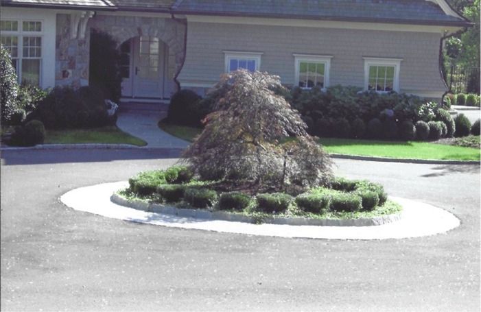 A house with a circular planter in front of it
