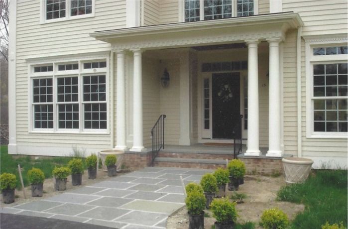 The front of a house with a porch and potted plants