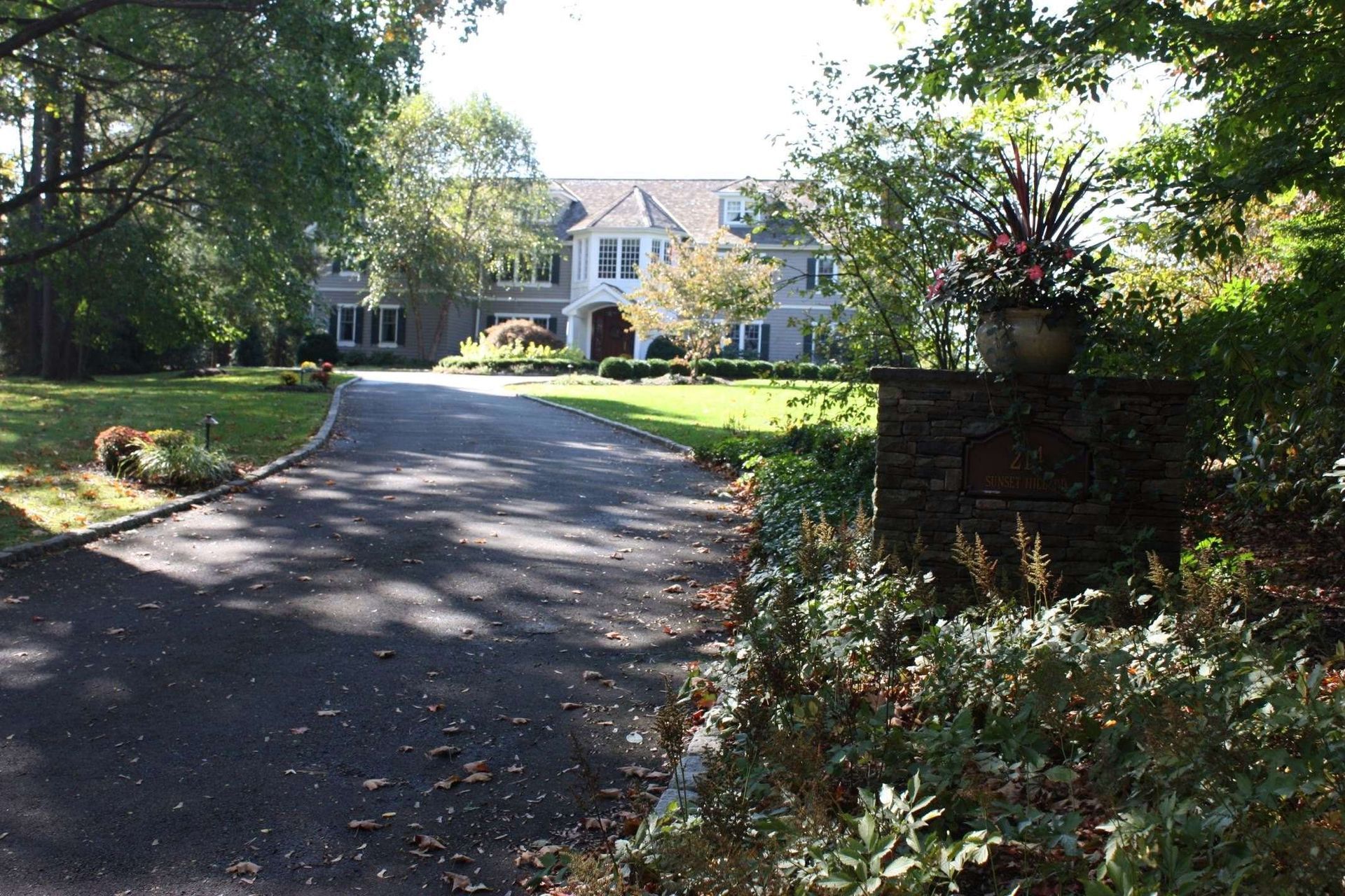 A driveway leading to a large white house