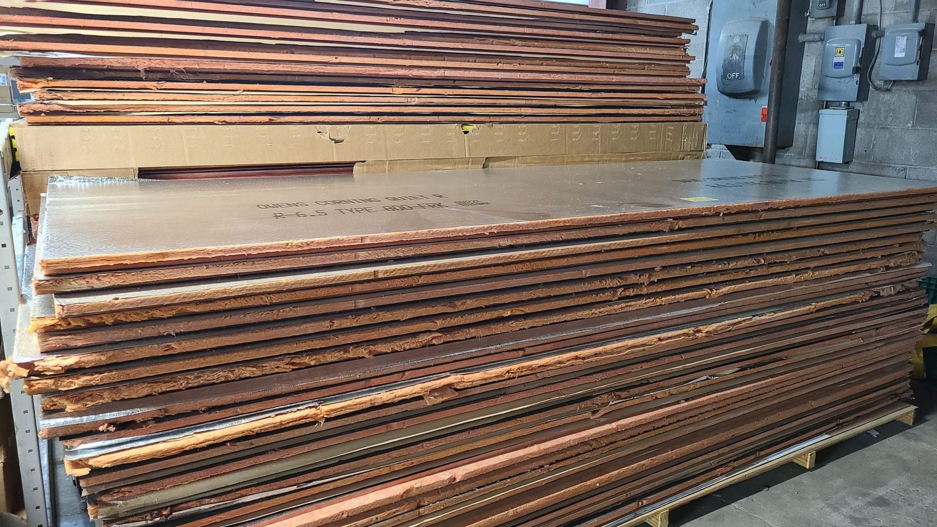 A stack of copper plates sitting on top of each other on a pallet.