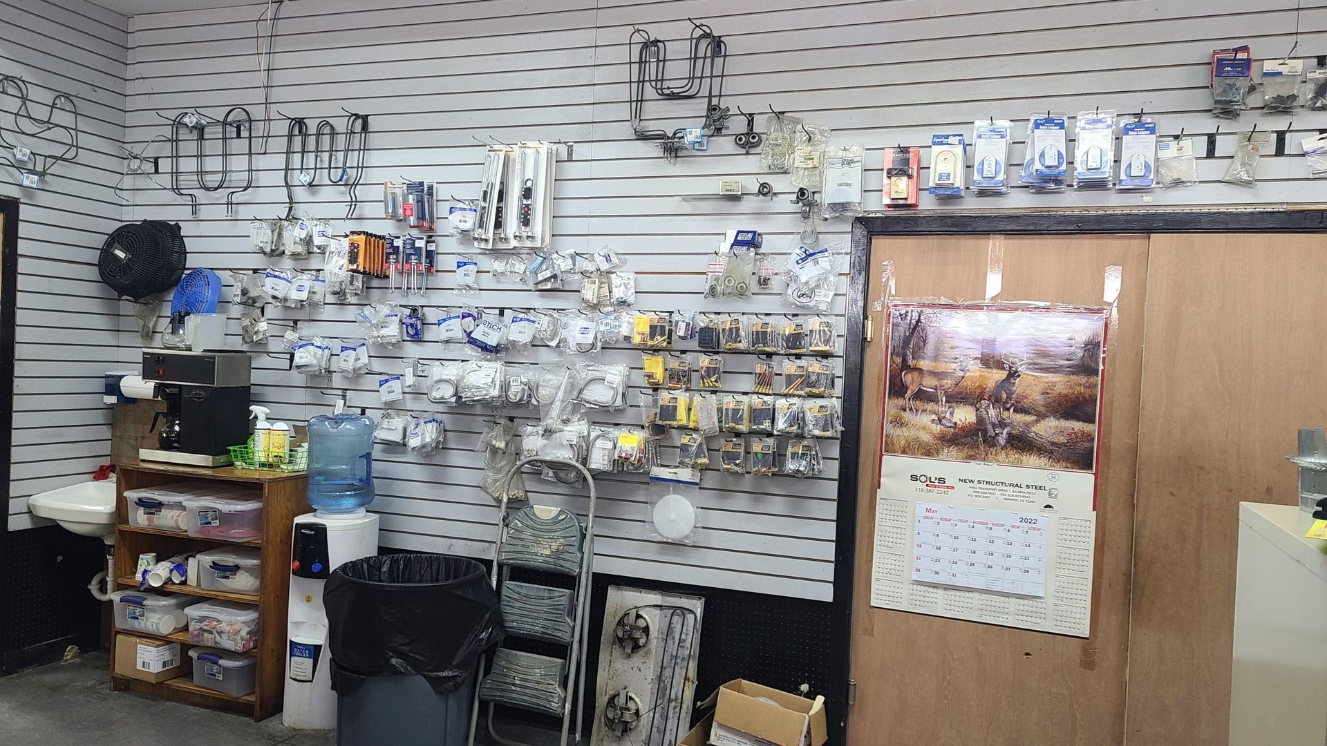 A store filled with lots of items and a calendar on the wall.