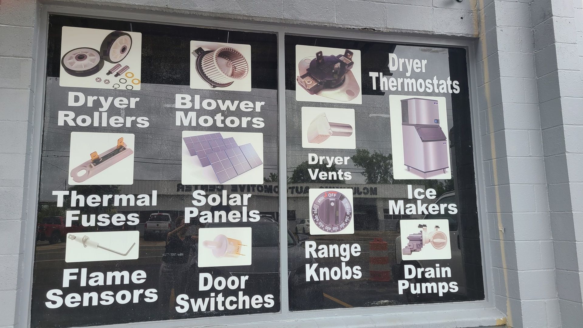 A sign in a window that says dryer rollers blower motors thermal fuses solar panels range knobs door switches