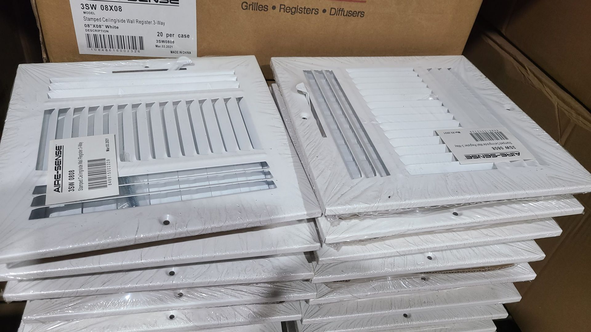 A stack of air vents are sitting on top of each other in a warehouse.