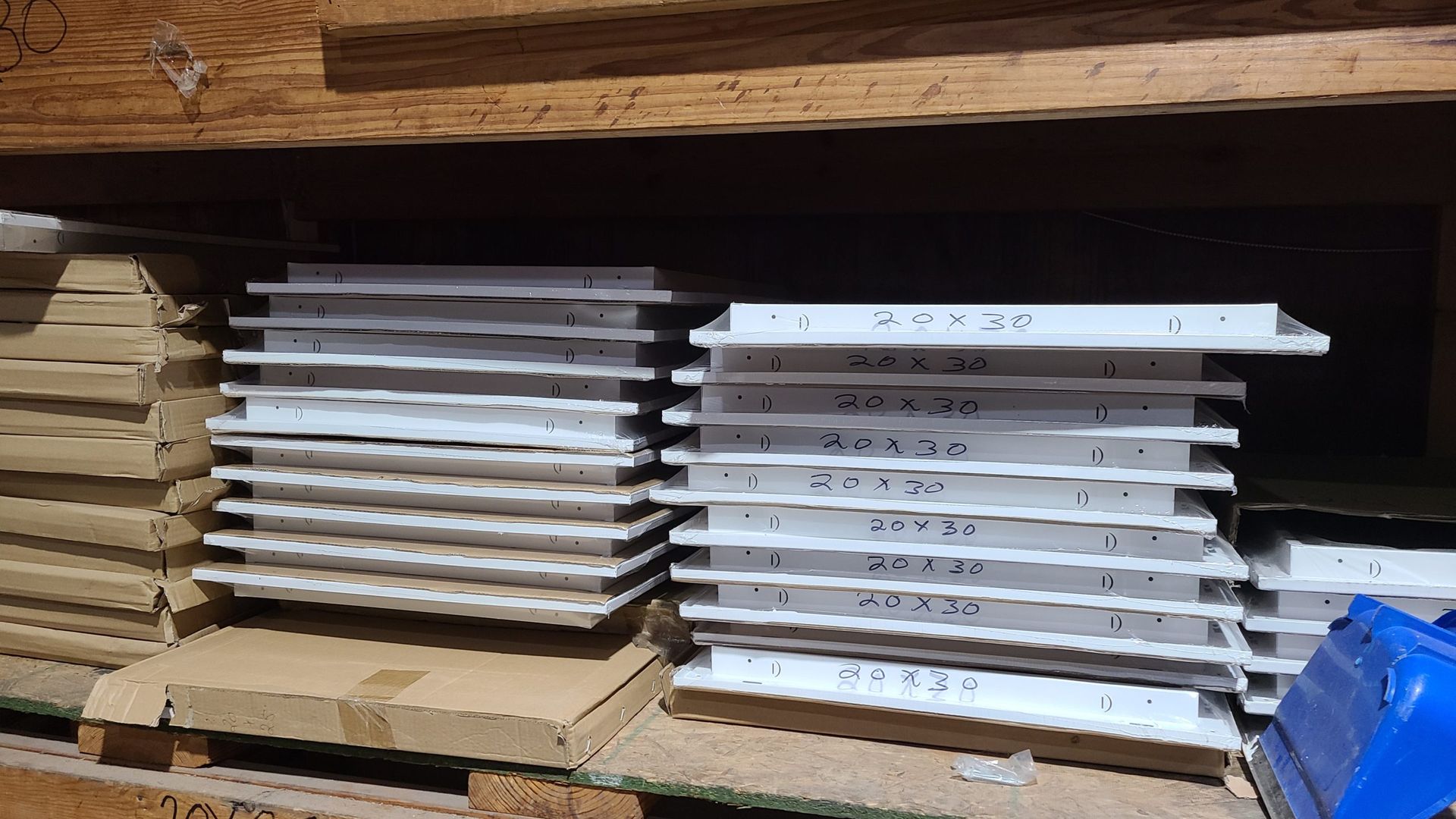 A stack of white tiles sitting on top of a wooden shelf.