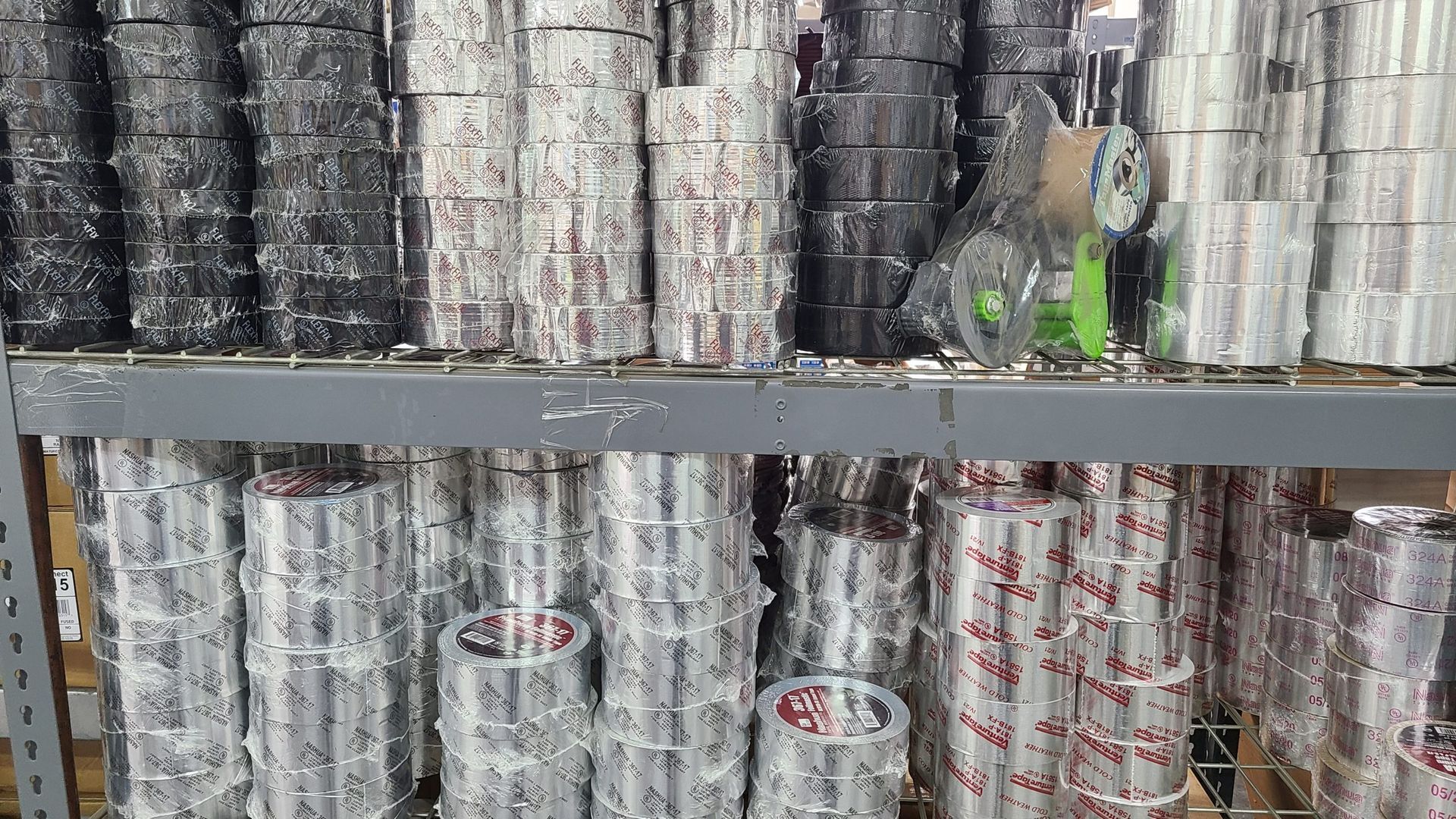 A shelf filled with rolls of paper cups in a store.