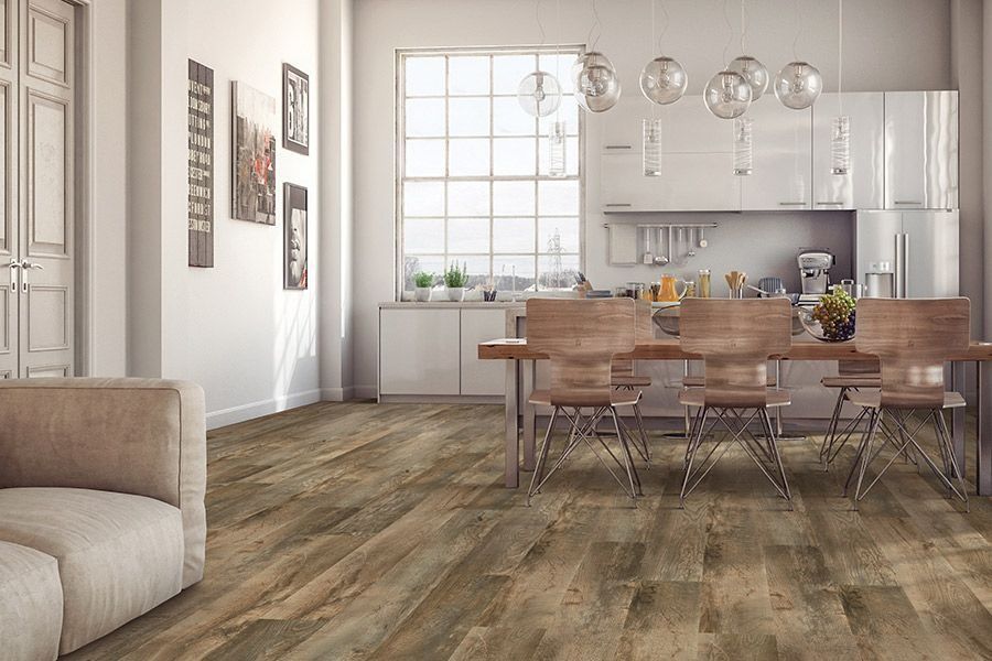 A living room with a dining room table and chairs and a kitchen.