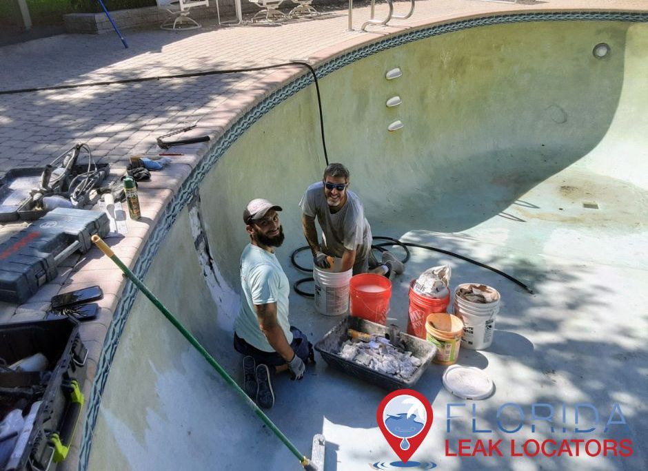 two men are working on a swimming pool