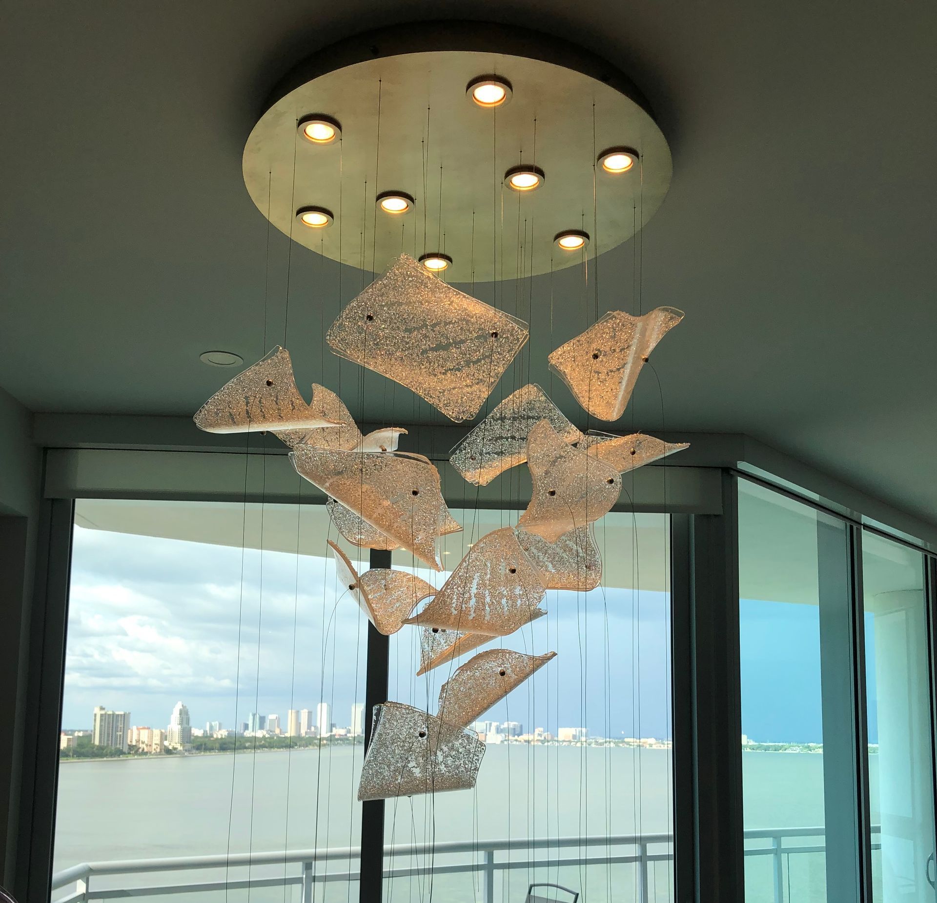 A chandelier is hanging from the ceiling in front of a window