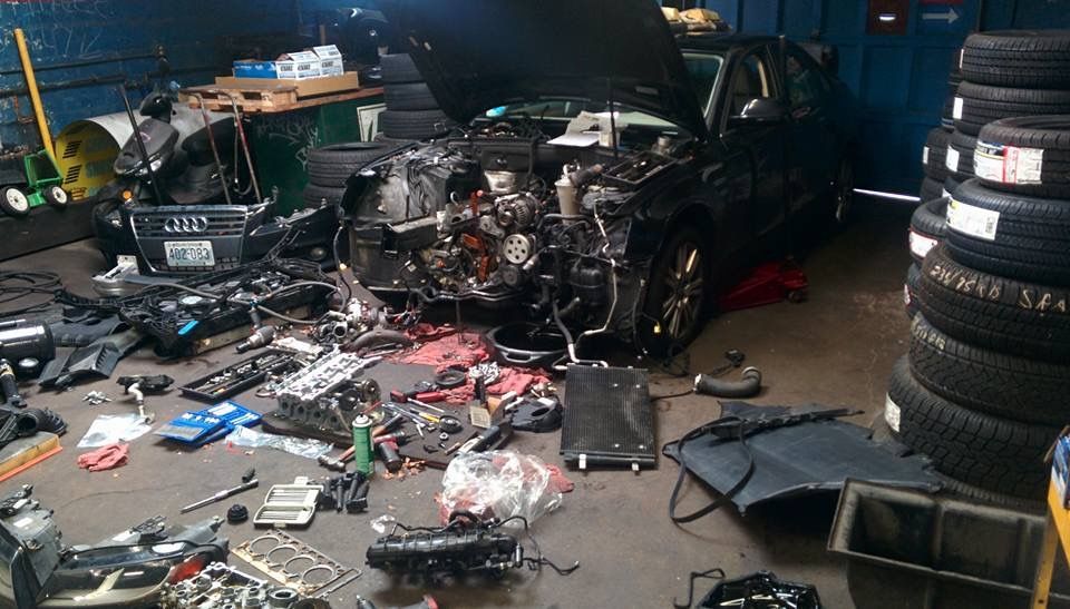 A damaged car is being worked on in a garage