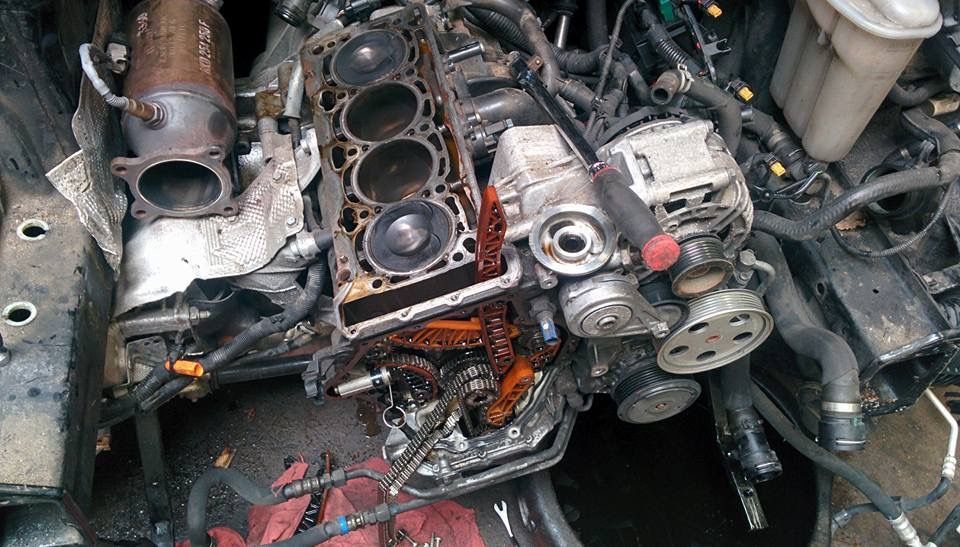 A close up of a damaged engine in a car.