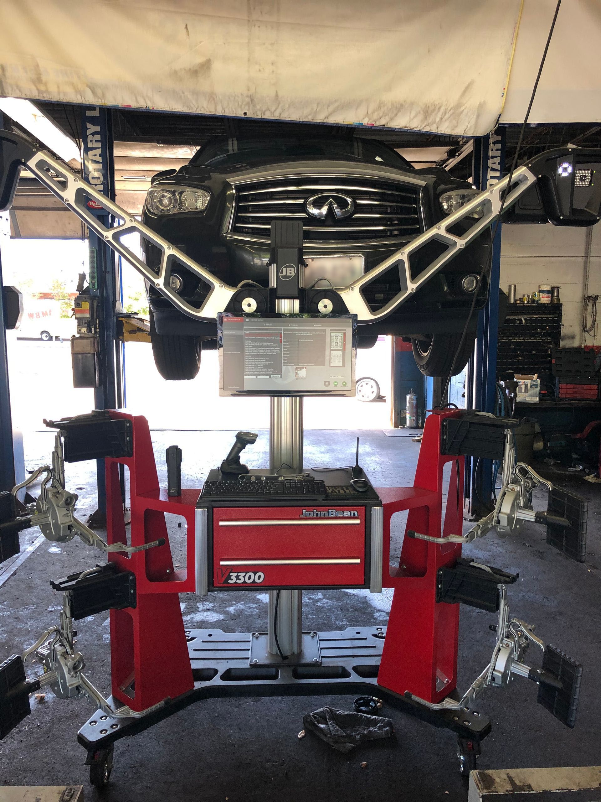 A car is being aligned in a garage with a machine.