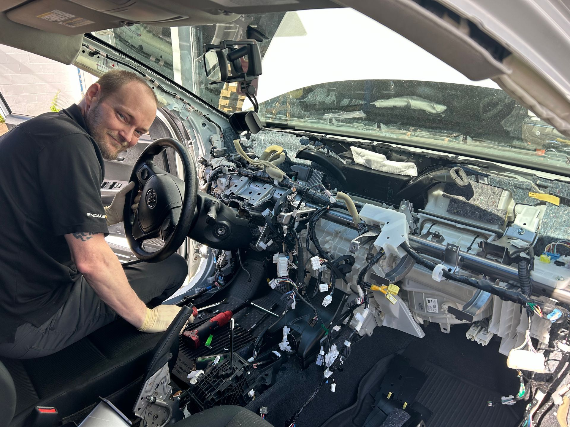 A man is working on the interior of a car.