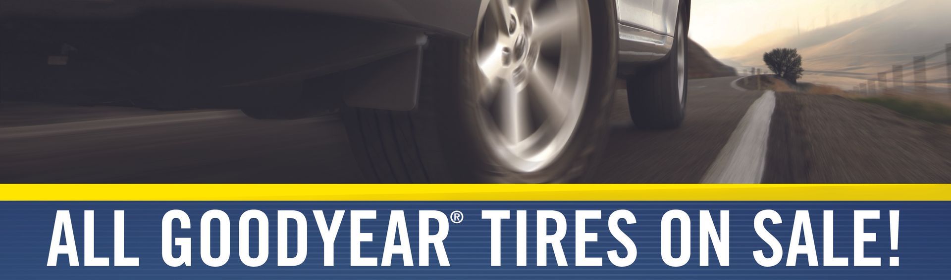 Goodyear tires sale banner with a car wheel on a road at sunset