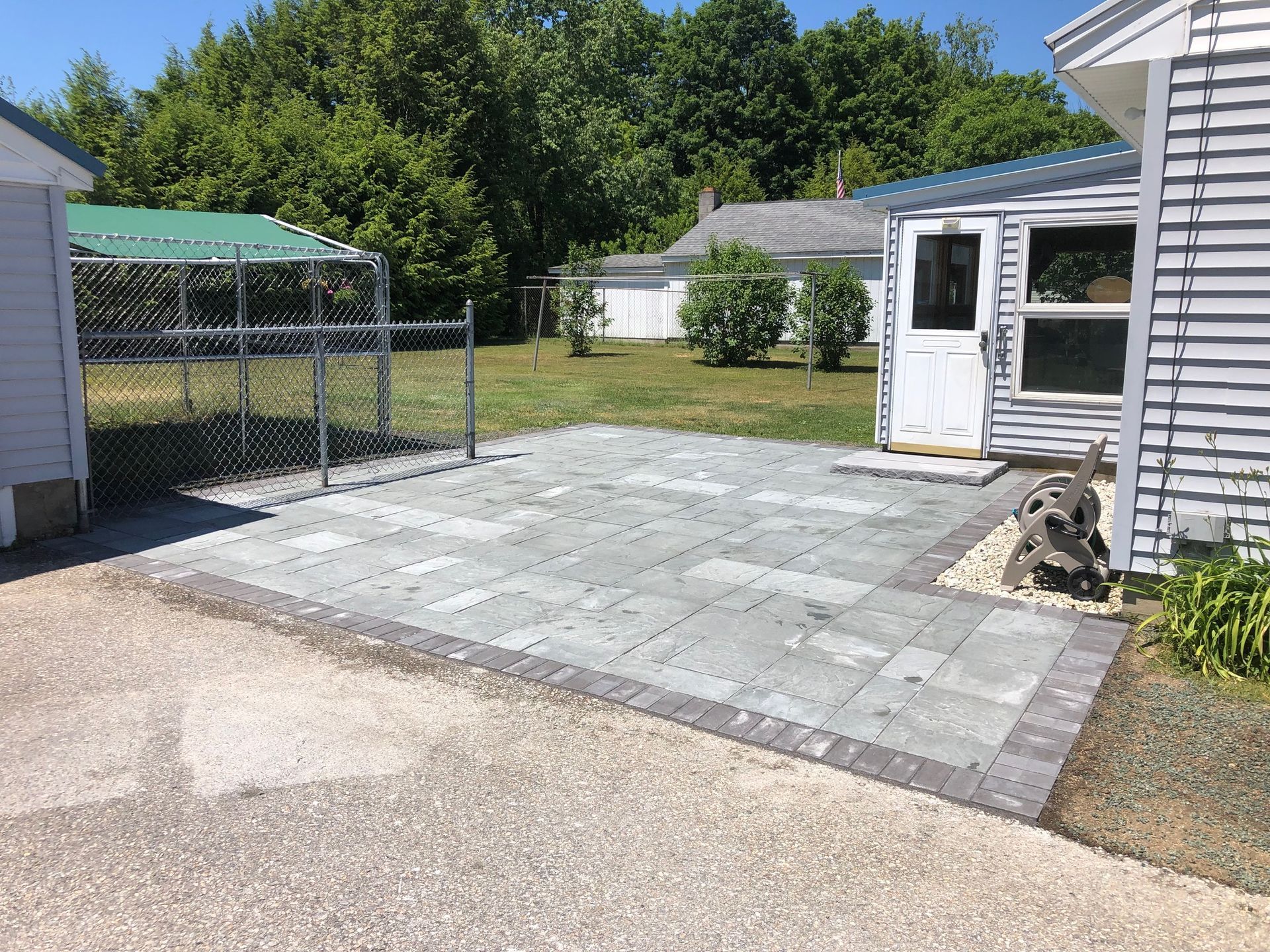 A house with a fence and a patio in front of it.