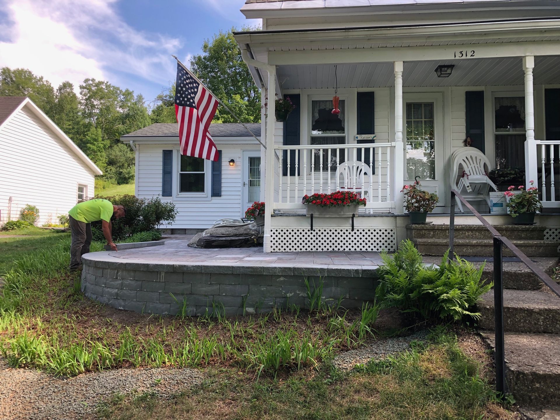 A man is working on the front porch of a house.
