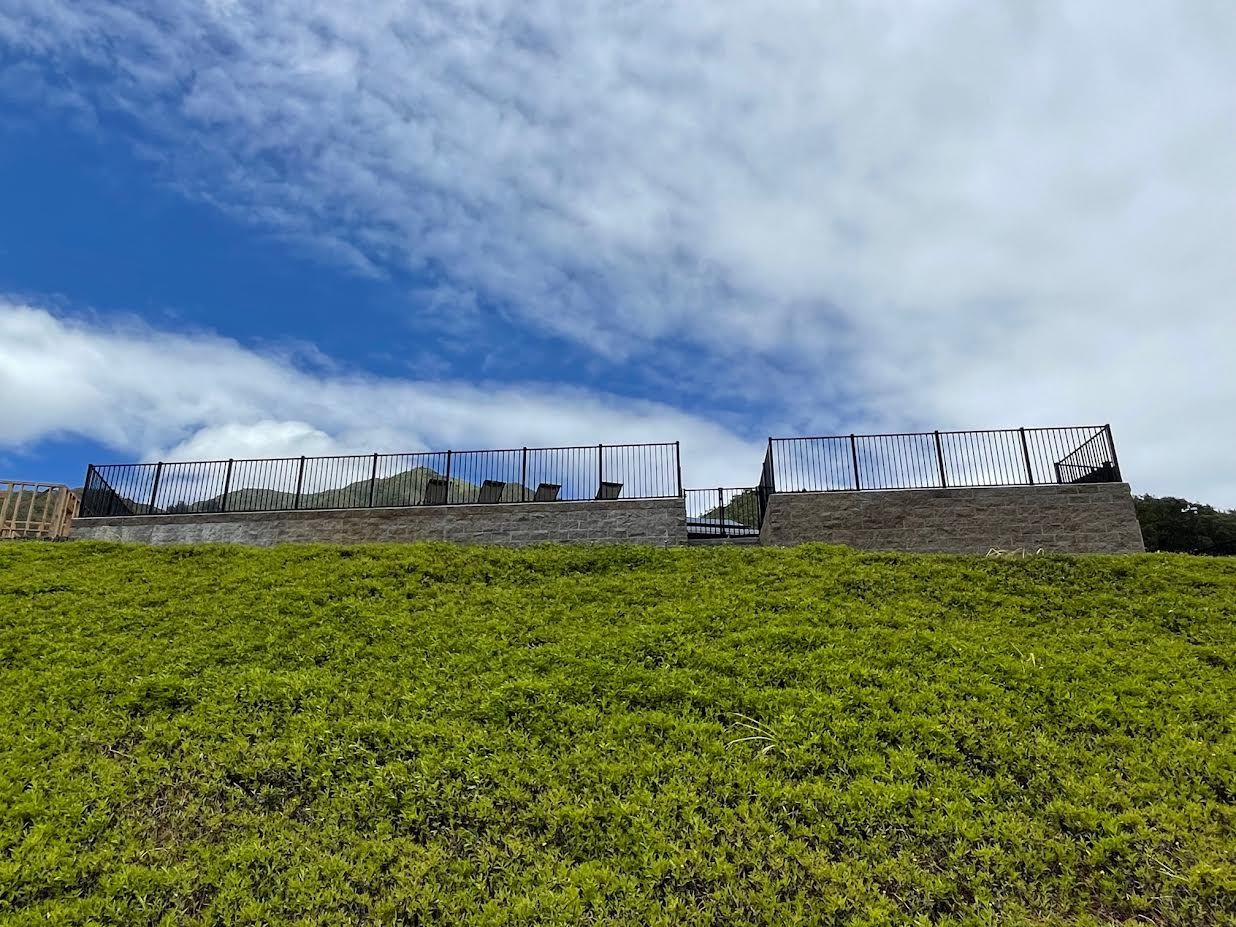 There is a fence in the middle of a grassy field.