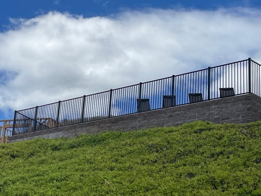 A fence is sitting on top of a grassy hill.