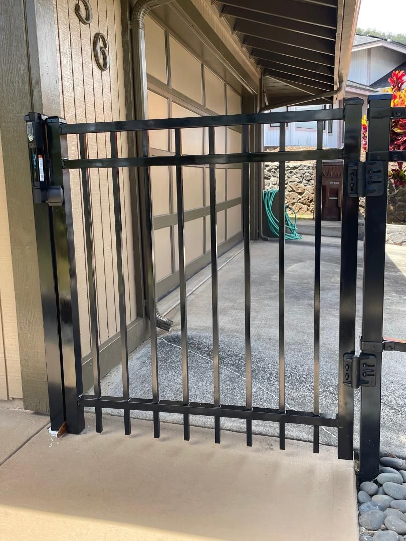 A black gate is sitting in front of a garage door.