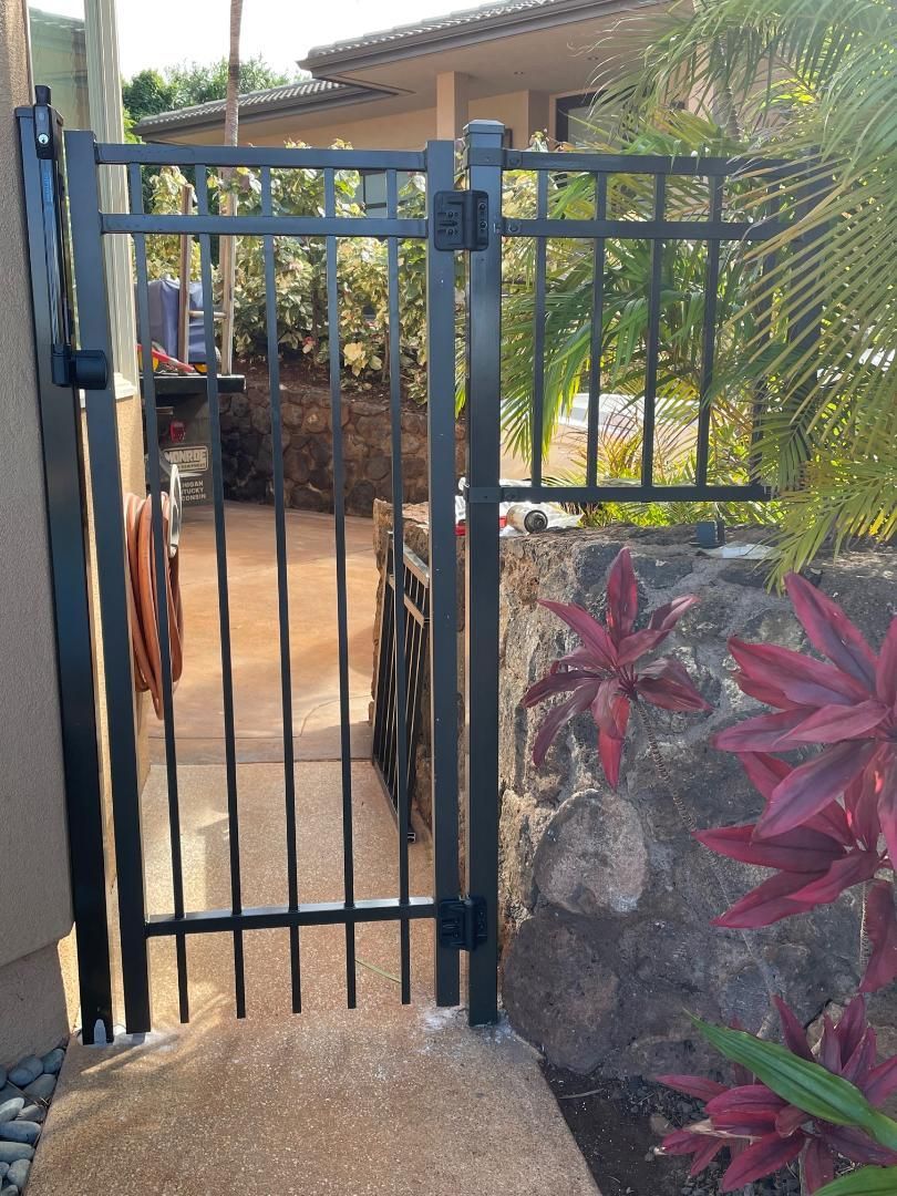 A wrought iron gate leading to a stone walkway