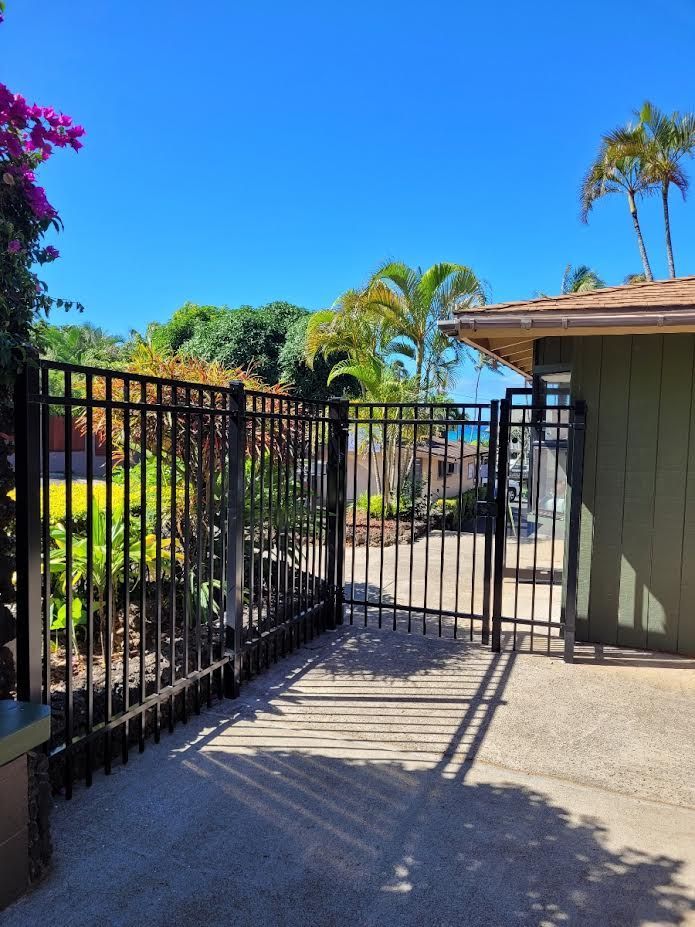 A fence with a gate leading to a house