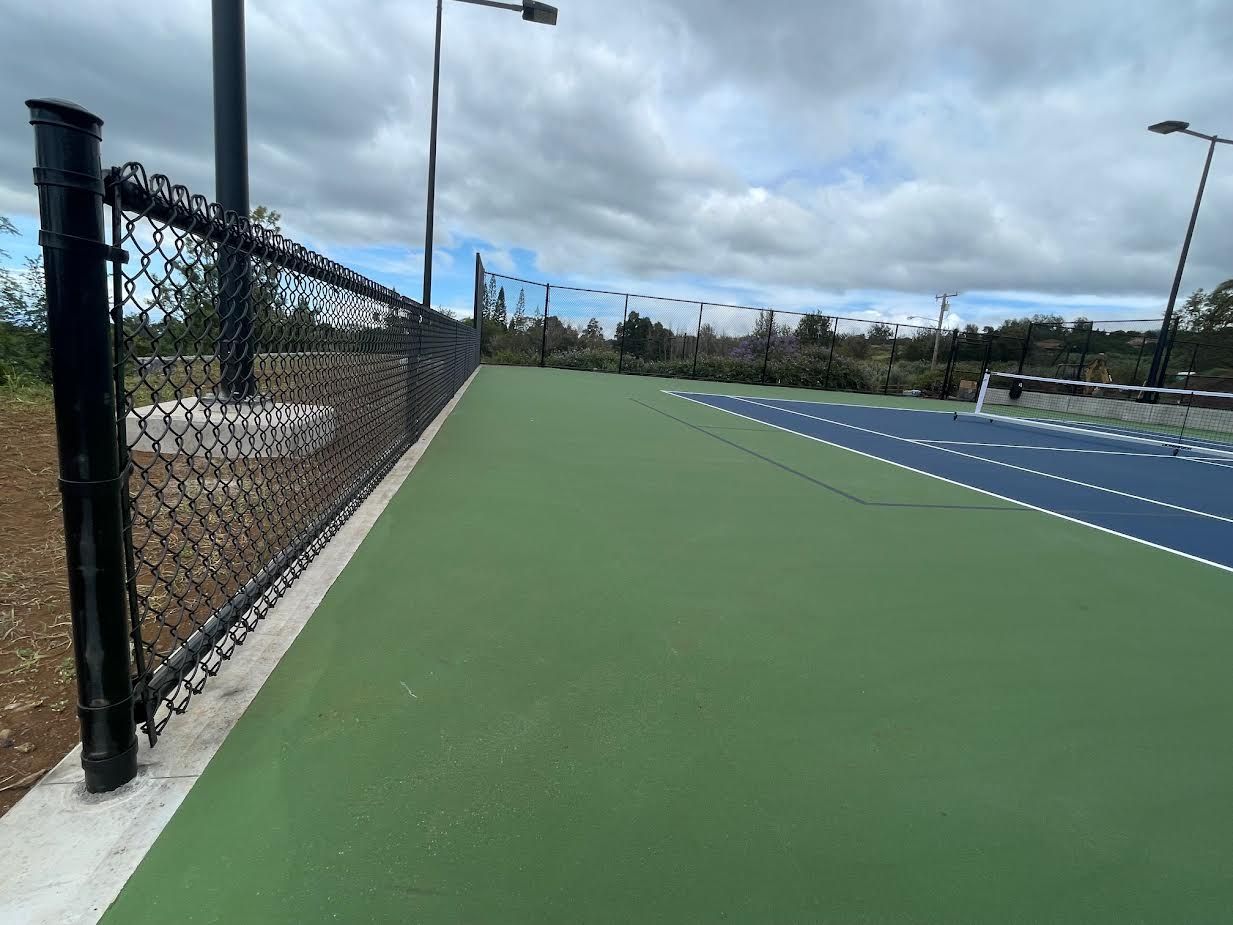 A tennis court with a chain link fence around it