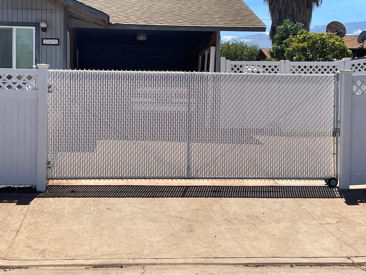 A white gate is sitting in front of a house.