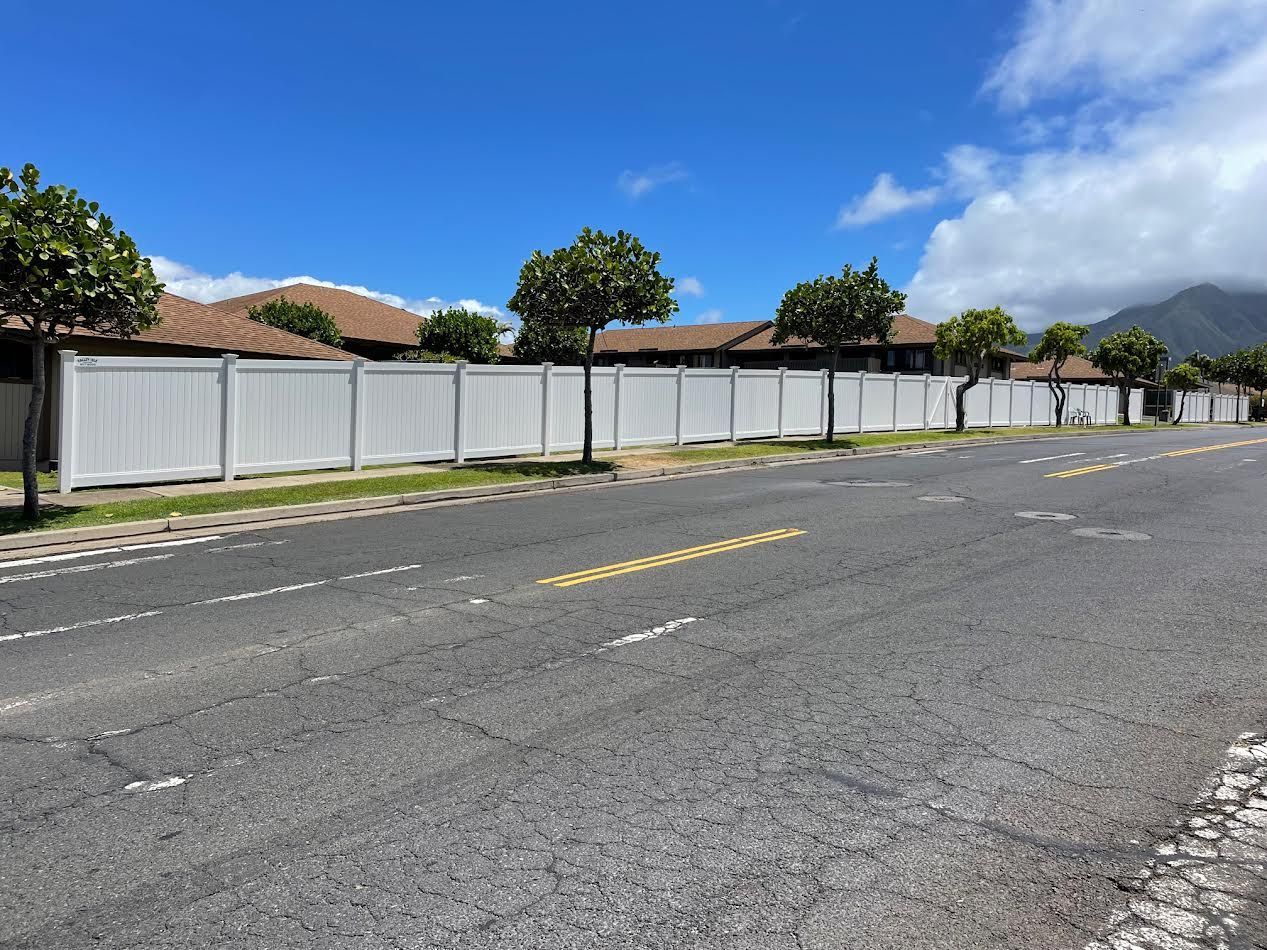 A white fence along the side of a road
