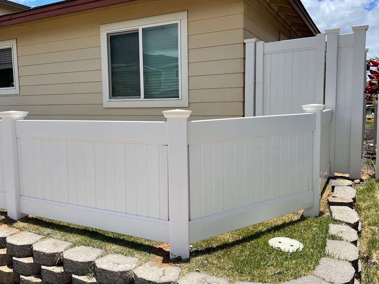 A white fence is sitting in front of a house.