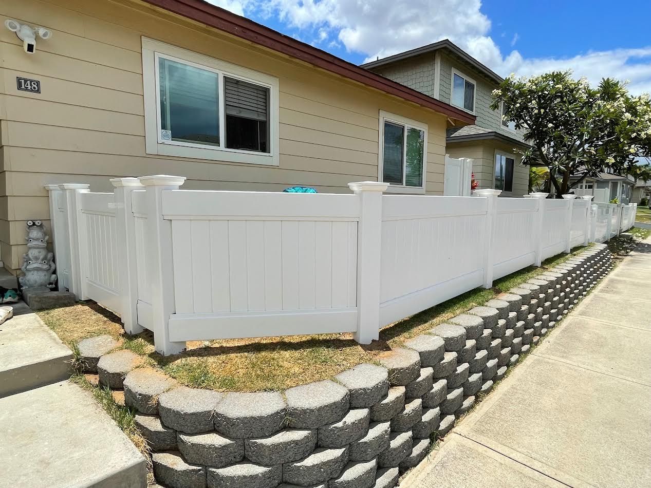 A white fence is sitting in front of a house.