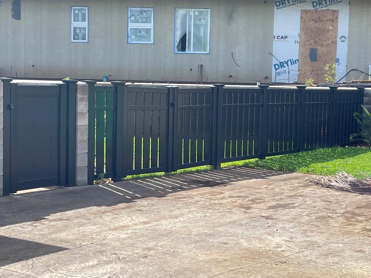 A black fence is in front of a house under construction