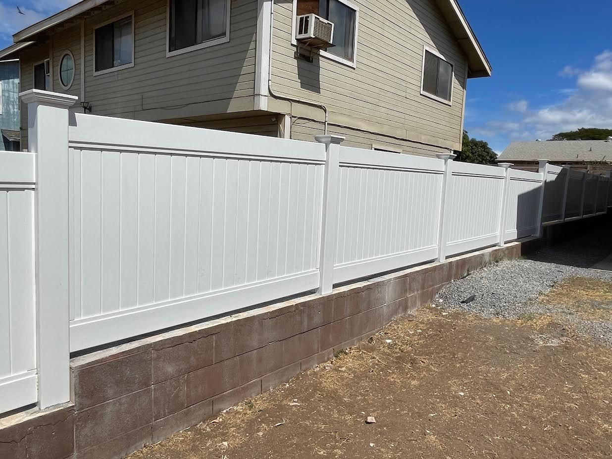 A white fence is in front of a house.